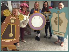 four girls in costumes holding up paper cutouts