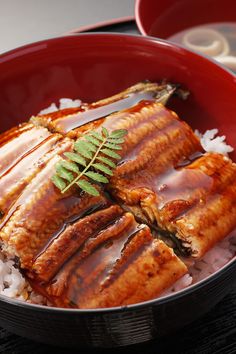 a red bowl filled with rice and meat