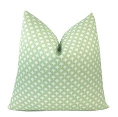 a green and white pillow on a white background