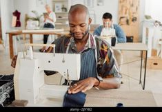 Dessinateur de mode, jeune homme et étudiant créateur dans un atelier pour coudre des vêtements et des vêtements. Travailleur d'usine, sur mesure et apprenti apprentissage de la couture Banque D'Images Daily Crafts, Sewing Factory, Designer Working, Sewing Projects Free, Work Aprons, Fashionable Clothes, Couture Mode, Jeans Fabric, African Men