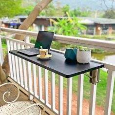 a laptop computer sitting on top of a wooden table next to a cup of coffee