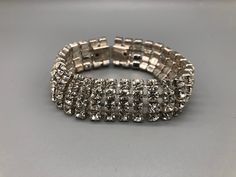 A beautiful vintage 4 strand silver tone clear crystal bracelet Approximate measurements  Bracelet Length - 7 inches * Due to this item being vintage there may be markings on the piece.  Please view the video and photos to see the condition of the jewellery. Silver Crystal Bracelet With Rhinestones For Formal Occasions, Formal Silver Crystal Bracelet With Rhinestones, Silver Crystal Bracelets With Jewels, Vintage Silver Bangle Crystal Bracelet, Vintage Silver Crystal Bangle Bracelet, Silver Metal Crystal Bracelet With Jewels, Silver Rhinestone Bracelet In Costume Jewelry Style, Silver Costume Jewelry Bracelets With Rhinestones, Silver Rhinestone Bracelet For Costume Jewelry