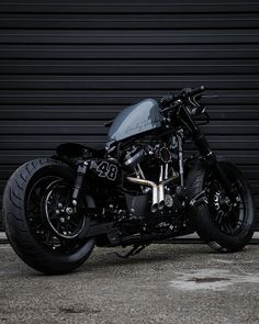 a black motorcycle parked in front of a garage door