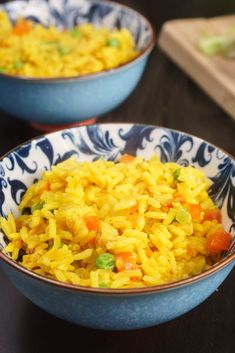 two bowls filled with rice and vegetables on a table