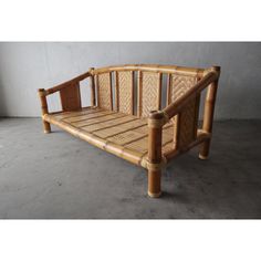 a wooden bench made out of bamboo sticks and wickers on concrete flooring