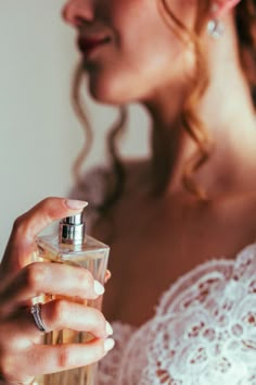 a woman holding a bottle of perfume in her hand