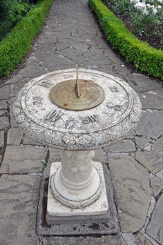 a stone fountain in the middle of a garden