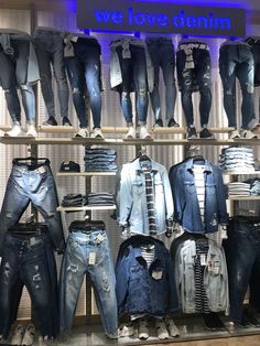 several pairs of jeans on display in a clothing store with the words we love denim written above them