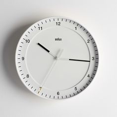 a white clock with black hands on a wall