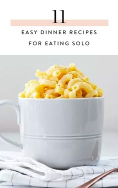 a white bowl filled with macaroni and cheese sitting on top of a table