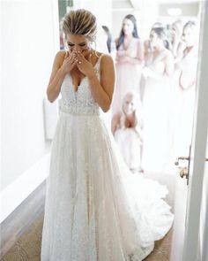 a woman standing in front of a mirror wearing a wedding dress