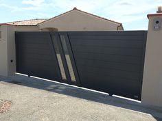 a large black gate in front of a house