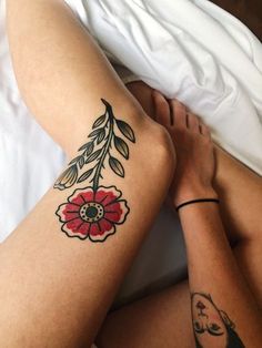 a woman laying in bed with her legs crossed and tattoos on her arms, both showing