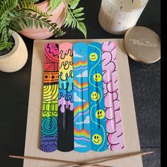 some colorful markers are sitting on a wooden board next to plants and potted plants