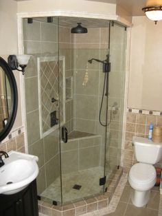 a bathroom with a walk in shower next to a white toilet and sink on the side