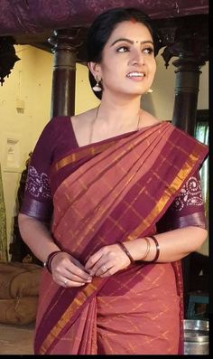 a woman in a sari is smiling for the camera