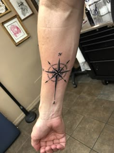 a person's foot with a compass tattoo on it