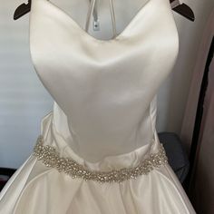 a white wedding dress hanging on a hanger