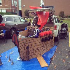 a car is parked in the parking lot with an open trunk and pirate ship on it