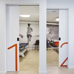 two doors open to show the inside of a room with an orange and white graphic on the wall