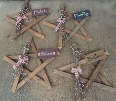 four wooden stars with name tags attached to them on the ground next to a sign that says faith, welcome, believe and faith