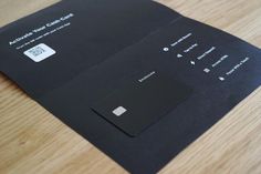 a close up of a black card on a wooden table