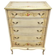 an antique chest of drawers with gold trimmings and flowers on the bottom drawer