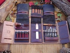 an assortment of leather items laid out on a bamboo mat with pine cones in the background