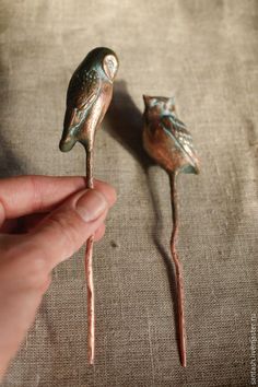 two small metal birds sitting on top of each other