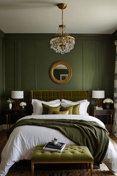 a bedroom with green walls, white bedding and a chandelier hanging from the ceiling