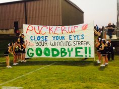 some cheerleaders are holding up a sign that says pucker up close your eyes please your winning streak goodbye