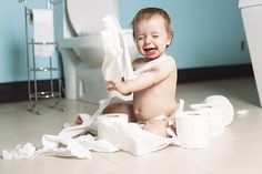 a baby sitting on the floor with toilet paper in front of him and saying, our child might be the reason you drink so enjoy this bottle on us