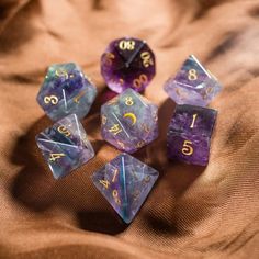 five dice that are sitting on top of a cloth