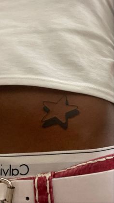 the back of a woman's stomach with a star tattoo on her left side