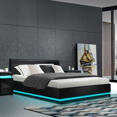 a modern bedroom with black and white furniture, blue lights on the bed frame and carpet