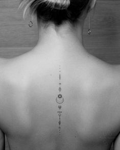 the back of a woman's neck with tattoos on her upper and lower back