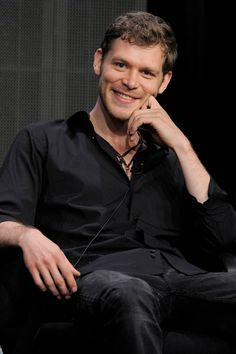 a man sitting in a chair smiling at the camera