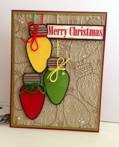 a christmas card with three ornaments hanging from it's sides and the words merry christmas on