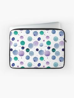 a laptop case with blue and green dots on it, sitting on a white surface