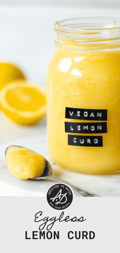 lemon curd in a glass jar with a spoon next to it and the words vegan lemon curd