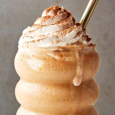 a close up of a drink with whipped cream and cinnamon on it's top