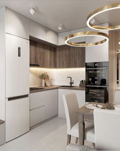 a modern kitchen with white chairs and wooden cabinetry is lit by round pendant lights