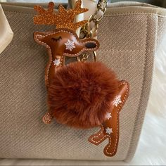 a purse with a deer keychain hanging from it's front and side