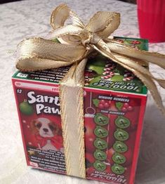 a small box wrapped in gold ribbon on a table