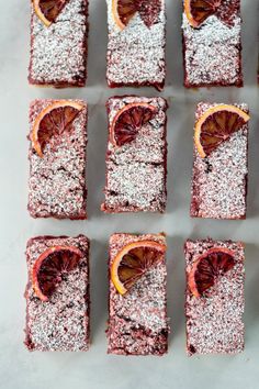 several pieces of cake with blood oranges on top and sprinkled with powdered sugar