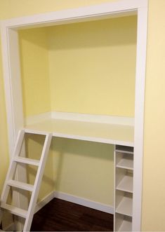 an empty room with a ladder in the corner and shelves on the wall above it