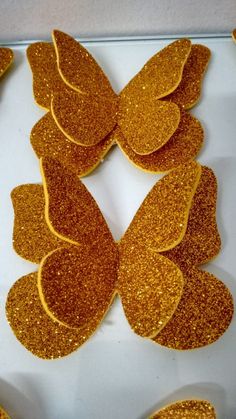 gold glitter butterfly cut outs on a white surface