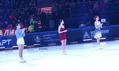 three women in short skirts skating on an ice rink