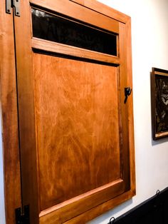 a wooden door with two pictures hanging on the wall