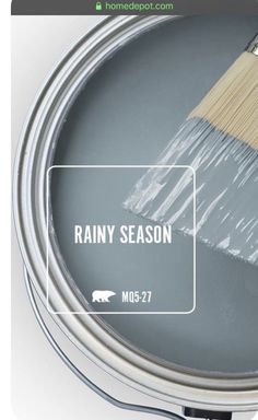 a paint can with the words rain season painted on it and a brush next to it